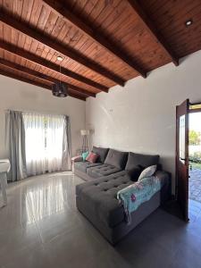 ein Wohnzimmer mit einem grauen Sofa und einer Holzdecke in der Unterkunft Casa fin de semana in Sierra de la Ventana