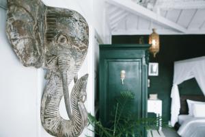 a statue of an elephant on the wall of a bedroom at White Tortoise Eco Villa's in Uluwatu