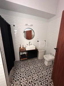 ein Badezimmer mit Waschbecken, Toilette und Spiegel in der Unterkunft Casa fin de semana in Sierra de la Ventana