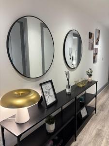 a living room with two mirrors and a table at Stylish stay Ware town with parking in Ware