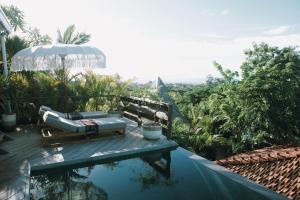 a bench sitting on a deck next to a pool at White Tortoise Eco Villa's in Uluwatu