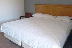 a large white bed with white sheets and pillows at OYO Hotel Durant MS Bowling Green Rd in Durant