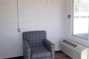 a room with a chair next to a window at OYO Hotel Durant MS Bowling Green Rd in Durant