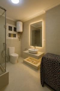 a bathroom with a sink and a toilet and a bed at Nasr City Airport شقة فاخرة مدينة نصر in Cairo