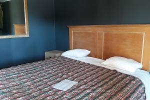 a bedroom with a bed with two pillows on it at OYO Hotel Durant MS Bowling Green Rd in Durant