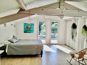 a bedroom with a bed and a chair and windows at Maison ZEN - Bayonne à 10 min in Mouguerre +40 photos