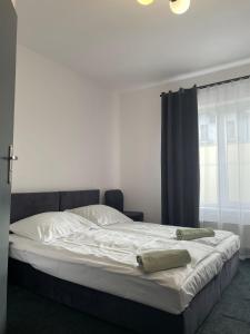 a bed with two towels on it in a bedroom at Stay Adventure Mrzeżyno in Mrzeżyno