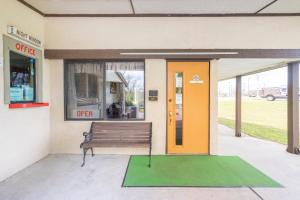 a building with a bench in front of a store at OYO Hotel Daleville AL Hwy 84 in Daleville