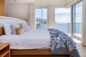 a bedroom with a bed with a large window at Sea Views Oceans Echo Villa in Fish Hoek