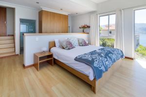 a bedroom with a large bed and a large window at Sea Views Oceans Echo Villa in Fish Hoek
