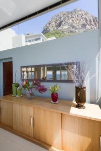 a kitchen with a large window with plants on a counter at Sea Views Oceans Echo Villa in Fish Hoek