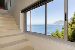 a room with stairs and a large window overlooking the ocean at Sea Views Oceans Echo Villa in Fish Hoek