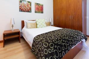 a bedroom with a large bed and a wooden cabinet at Sea Views Oceans Echo Villa in Fish Hoek +24 photos