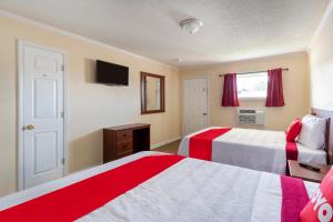 a bedroom with two beds with red and white at OYO Hotel Cave City KY in Cave City +19 photos