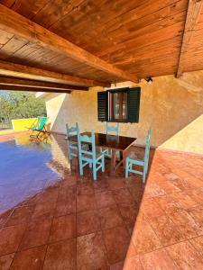 a patio with a table and chairs and a pool at Villa Scirocco in Cala Liberotto