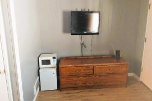 a room with a dresser and a television on a wall at Love Hotels Desert Inn & RV by OYO at Boysen Wind River WY in Shoshoni +16 photos