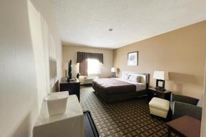 a hotel room with a bed and a couch at FairBridge Inn & Suites Batavia-Darien Amusement Park in Batavia