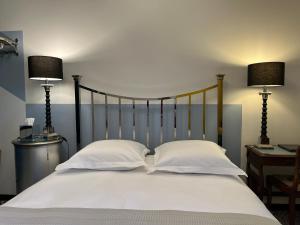 a white bed with two pillows and two lamps at Chez Montiz in Montazels