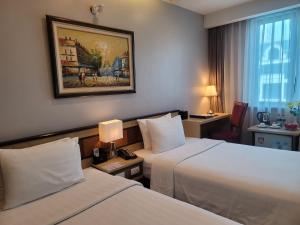 Postel nebo postele na pokoji v ubytování Luxeden Hotel Hanoi