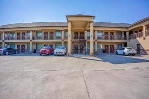 a large building with cars parked in a parking lot at Moulton Inn & Suites By OYO Near Shiner TX in Moulton