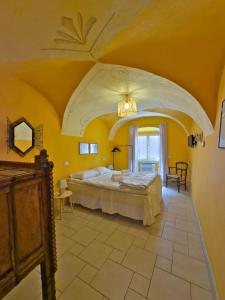 ein Schlafzimmer mit einem großen Bett in einem gelben Zimmer in der Unterkunft Sardinian Gallery Seminario in Bosa