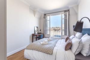 a bedroom with a large bed with a large window at GuestReady - Designer Apartment - Eiffel Tower View! in Paris