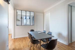 een eetkamer met een tafel en stoelen bij GuestReady - Designer Apartment - Eiffel Tower View! in Parijs