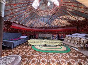 a room with two beds and a large ceiling at Bakytzhan hotel in Kurmenty