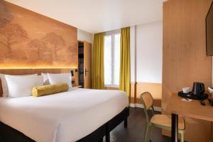 巴黎Hôtel WYLD Saint Germain的一间酒店房间，配有一张大床和一张书桌