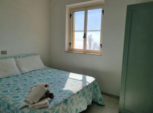 a bedroom with a bed with a teddy bear on it at Villa Smeraldo - Appartamento Fronte Mare a Capo Rizzuto in Capo Rizzuto +10 photos