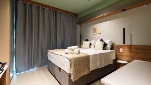 a bedroom with a bed with a stuffed animal on it at By DH: Santa Cecília Prime: Sofisticação e Lazer Completo em um Só Lugar in Sao Paulo +22 photos