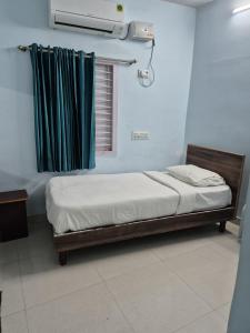 a small bed in a room with a window at KN residency, near Trichy Airport in Tiruchirappalli +8 photos