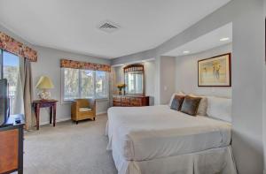 a bedroom with a bed and a desk and a television at Port O Call C204 by Wild Dunes, Ocean View Condo in Isle of Palms