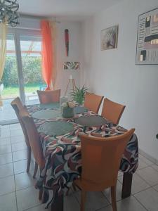 a dining room table with chairs and a table cloth at Location de vacances avec terrasse pour 6 pers, à 2 mn des plages, centre ville et commodités in Douarnenez
