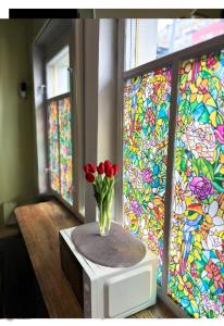 un jarrón de tulipanes rojos en un microondas con vidrieras en Chisinau Hostel, en Chişinău