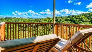 a bench sitting on a deck with a view of the mountains at Teniqua Treetops in Sedgefield