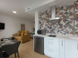 a kitchen and living room with a couch and a table at Vaiche Boa! in Corcubión