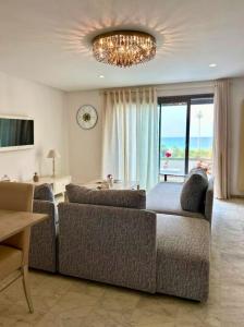 a living room with two couches and a chandelier at Luxueux appartement en bord de mer in Sousse