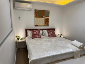 Un dormitorio con una cama grande con almohadas rojas. en Chadstone Holiday Village, en Oakleigh South