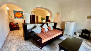 Schlafzimmer mit einem Bett mit Kissen und einem Kühlschrank in der Unterkunft Villablanca Garden Beach Hotel in Cozumel