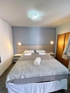 a bedroom with a large bed with two towels on it at Flat Atlântico Neto in Fortaleza +133 photos