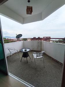 un balcon avec des chaises et une table et une vue dans l'établissement Lovers Island homestay, à Batu Ferringhi