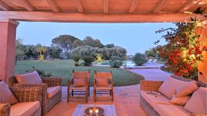 a patio with a couch and chairs and a garden at Villa Zagara 6 by Massimo Villas in Castelvetrano Selinunte