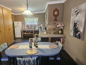 a dining room with a blue table and chairs at Apricity Inn in Louis Trichardt