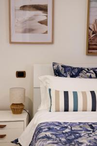 a bedroom with a bed with blue and white pillows at Casa Acqua Marina in Castiglione della Pescaia