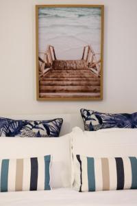 a bedroom with a bed with pillows and a picture on the wall at Casa Acqua Marina in Castiglione della Pescaia