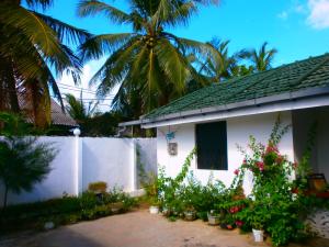 a white house with a palm tree in the background at 20 House Arugam in Arugam Bay