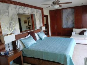 a bedroom with a bed with a blue comforter and a mirror at Lovely modern beach Villa in Cruz de Huanacaxtle +43 photos