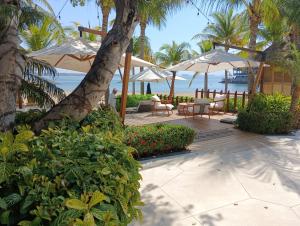 a patio with chairs and umbrellas on the beach at Lovely modern beach Villa in Cruz de Huanacaxtle