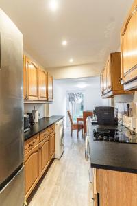 a kitchen with wooden cabinets and a stainless steel appliance at Chichester City Retreat - Stylish 4 Bed with LEGO Room, WFH Office and Free Parking in Chichester